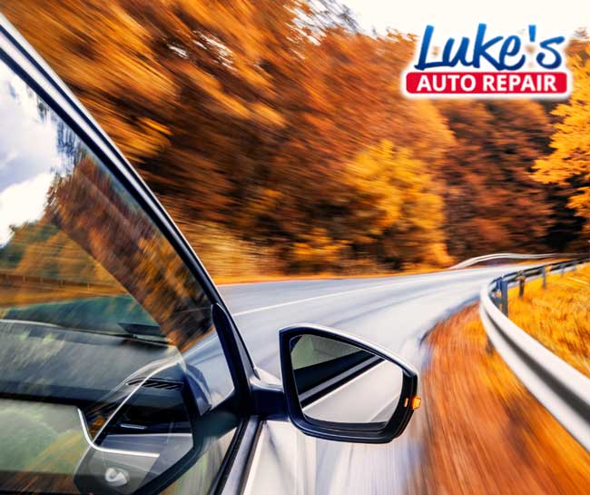 Car driving along a windy road in the peak of fall colors in the Coulee Region. 